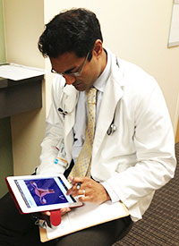 Medical student consults study materials on his iPad.